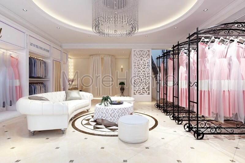 Thiết kế nội thất showroom áo cưới Calla Lily đẹp với sự có mặt của bộ sofa da màu trắng cùng với thanh treo quần áo màu đen tạo điểm nhấn nổi bật cho không gian căn phòng